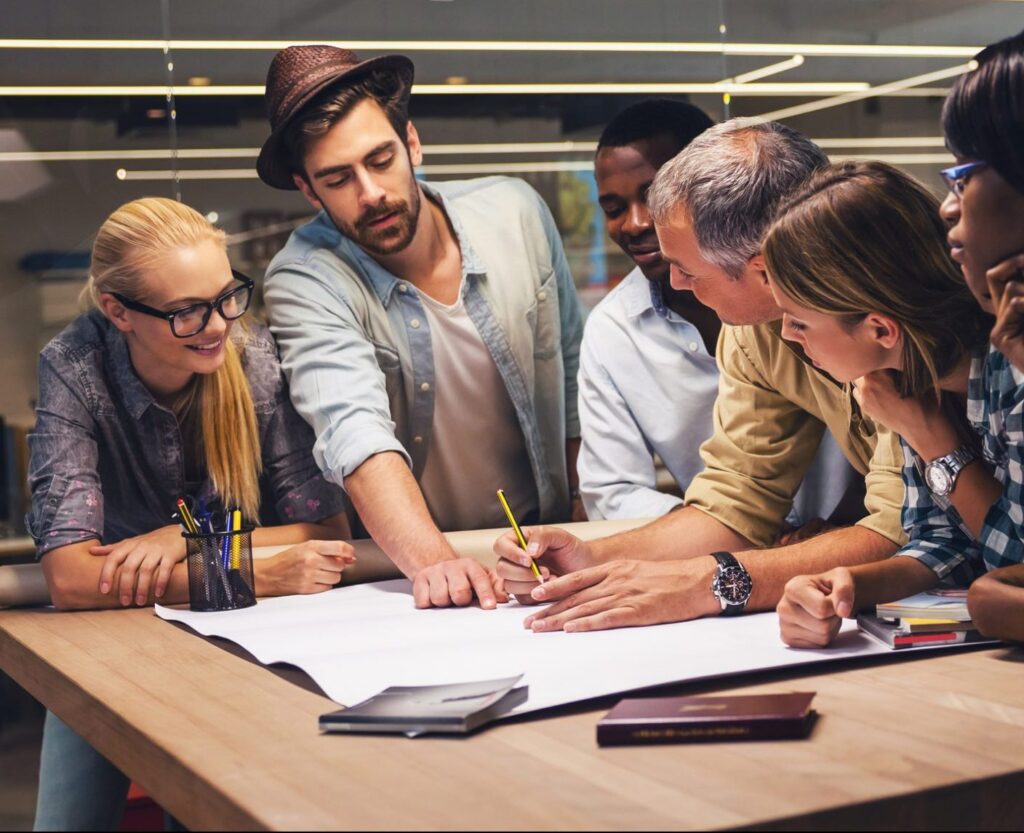 Group of employees brainstorming and working together on a poster