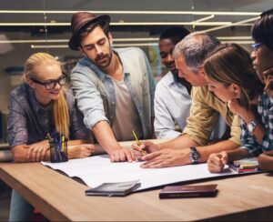 Group of employees brainstorming and working together on a poster