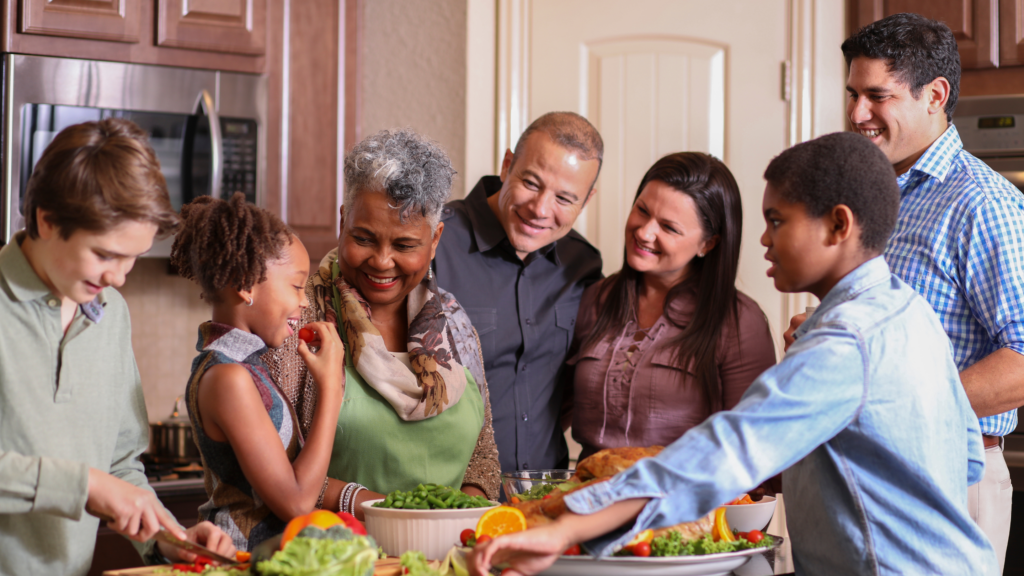 Happy people standing around table with food.