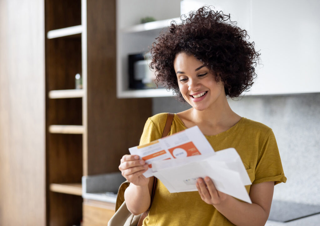 Woman opening mail in kitchen