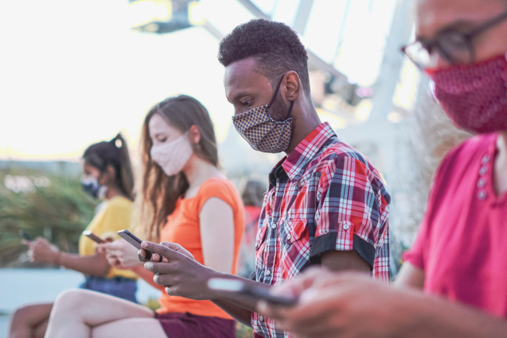 group of people on smart phones wearing face masks