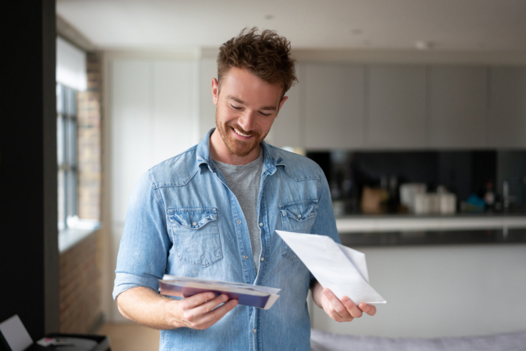 Man smiling and reading mail