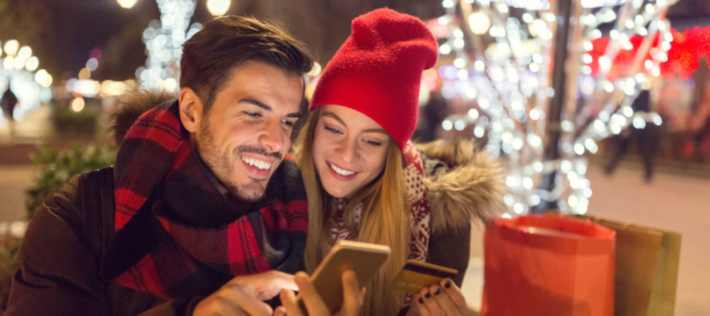 Couple smiling at phone while in winter clothing
