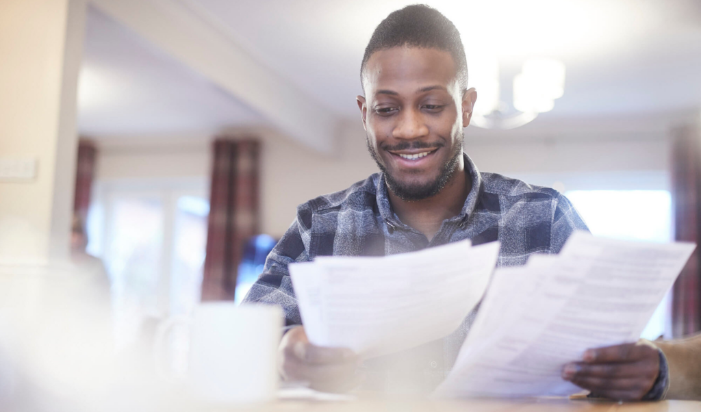 Man smiling and reading papers
