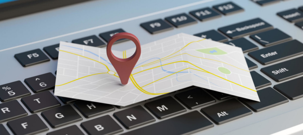 map with a pin in the middle situated on a keyboard