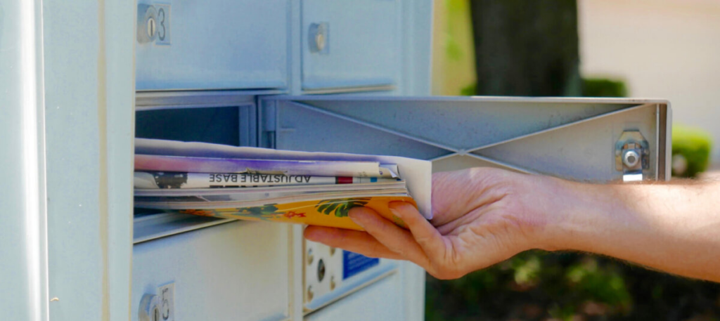 person removing newspaper from mailbox
