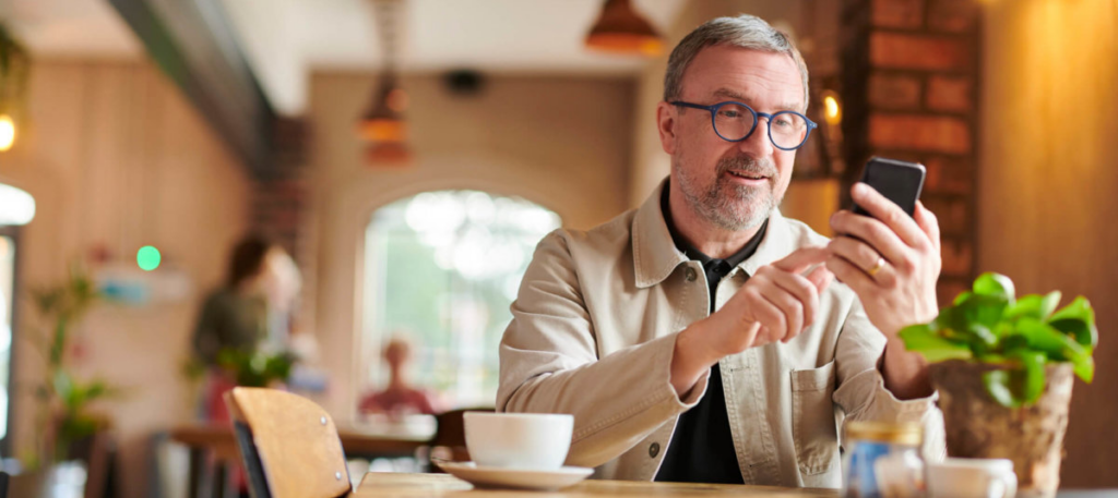 man using smart phone at cafe